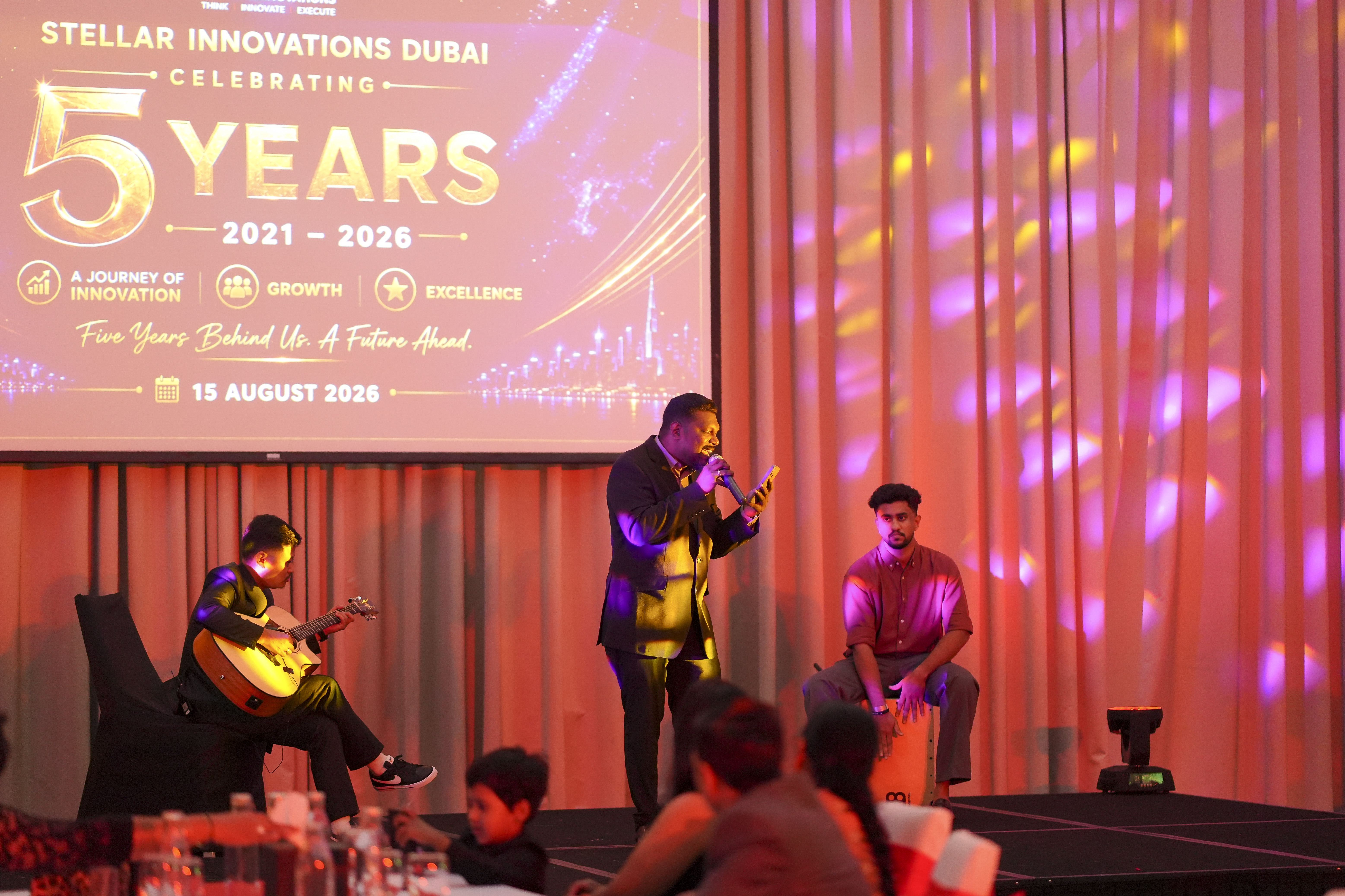 Three colleagues performing together on stage